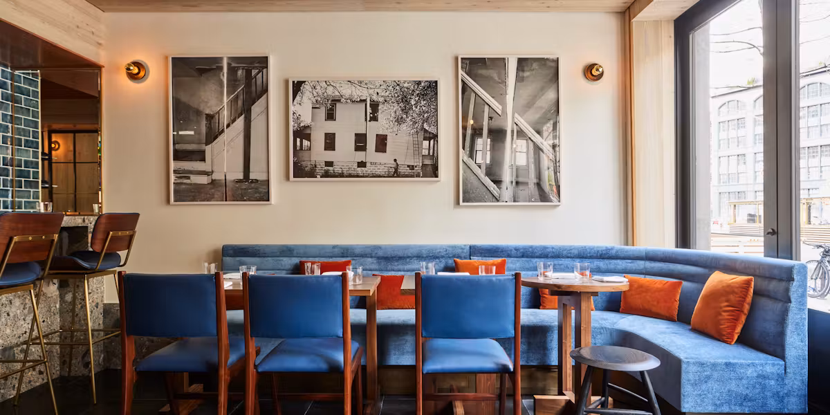 Blue seating and bold orange pillows create a welcoming corner at One White Street