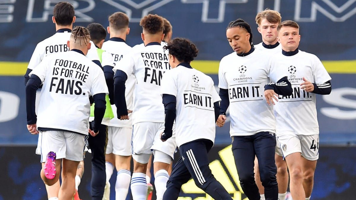 Leeds United wearing shirts that said “Earn It” on the front and “Football Is For the Fans” on the back