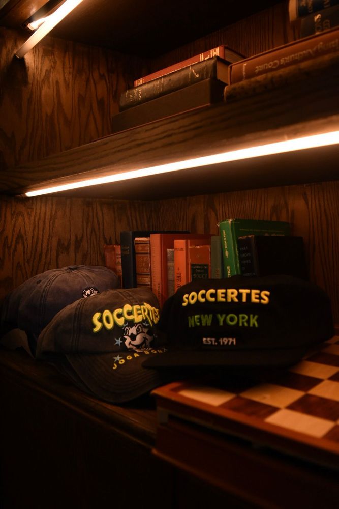 Soccertes caps lined up between classics on the shelf