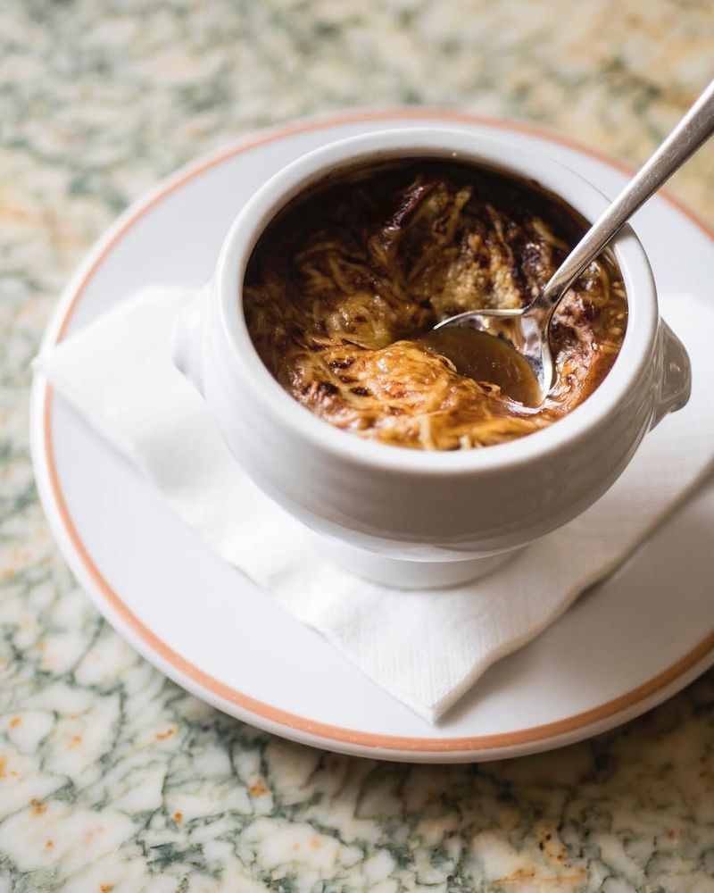 A comforting traditional crusted onion soup served at Angelina Paris
