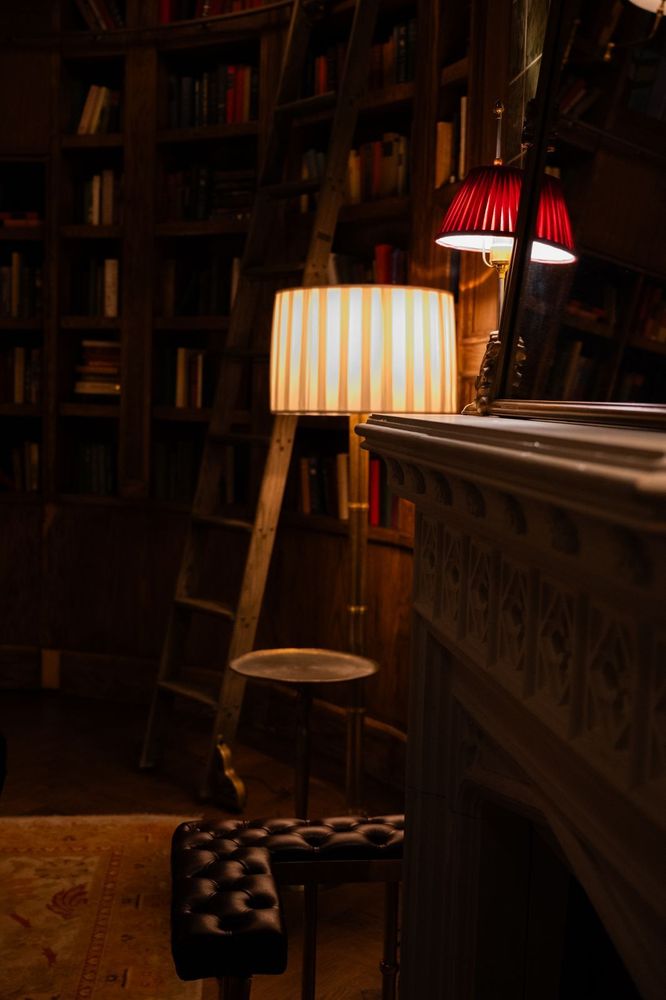 A striped floor lamp casts a warm glow at Maxwell, where custom lighting shapes the tone of quiet moments.