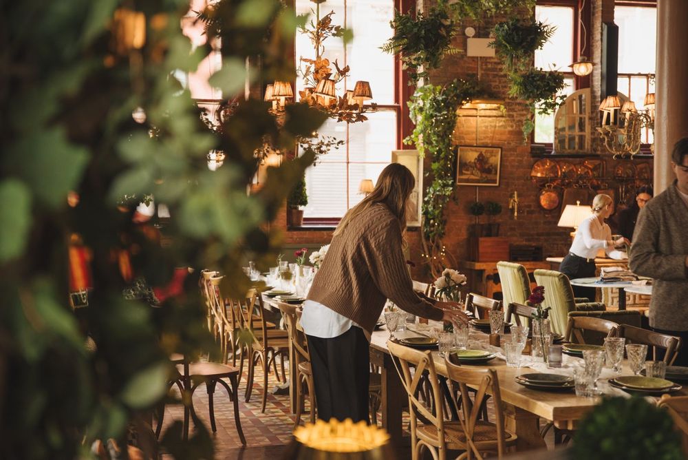 Final touches before guests arrive — long tables, and a room set for celebration.