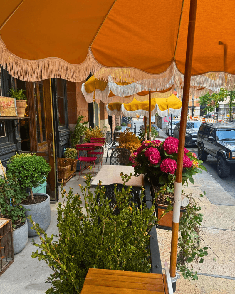 Outdoor table at Maxwell’s patio surrounded by fresh flowers and umbrellas.