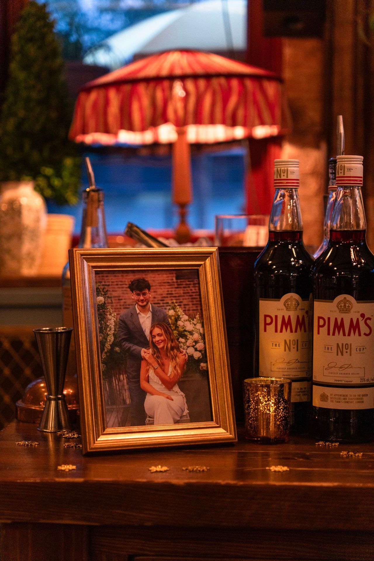 A framed wedding photo alongside signature drinks turns the bar into a personalized, story-driven centerpiece.