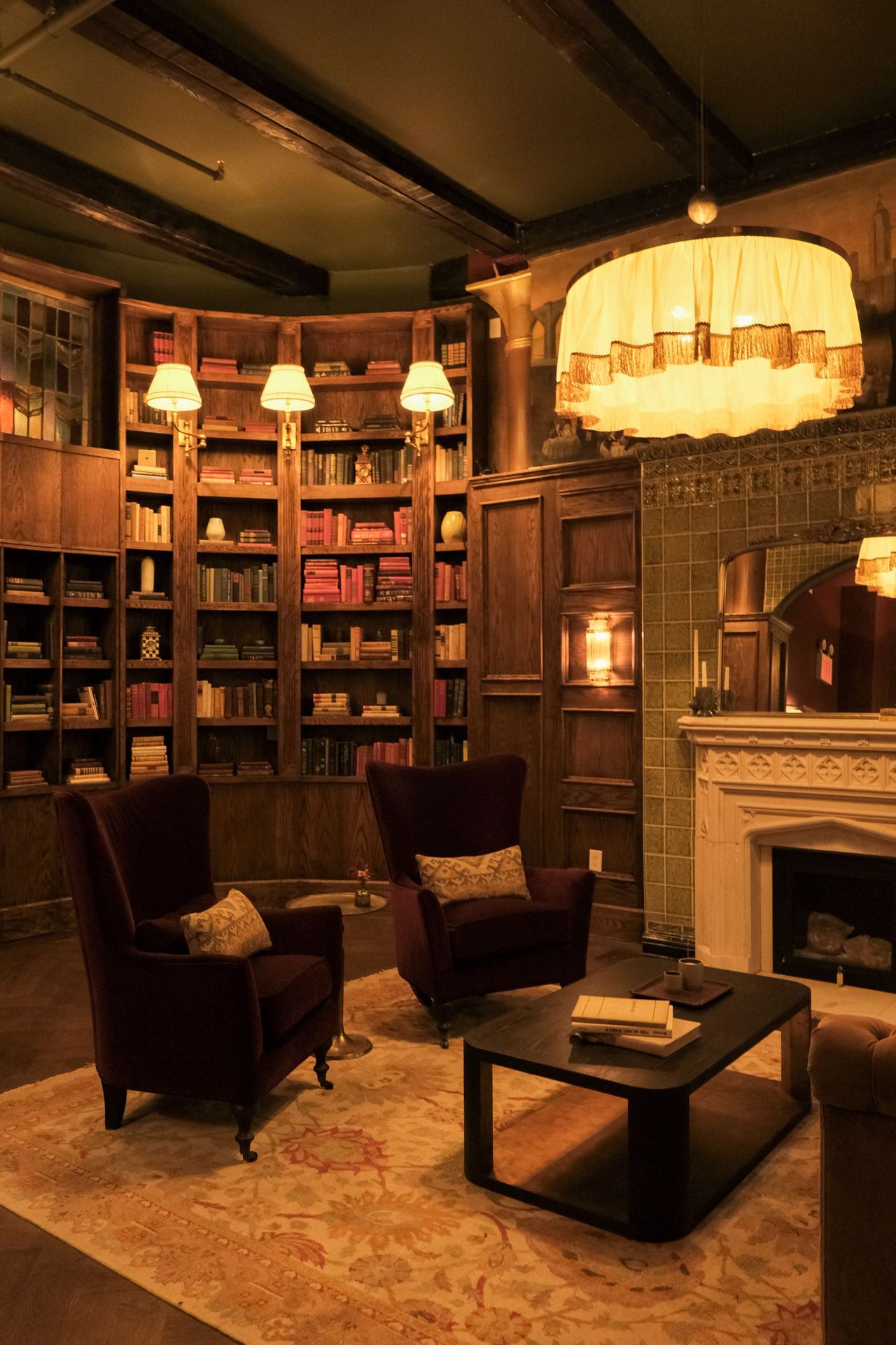 The Maxwell chandelier brings warmth and softness to rows of books, turning the room into a place meant for lingering