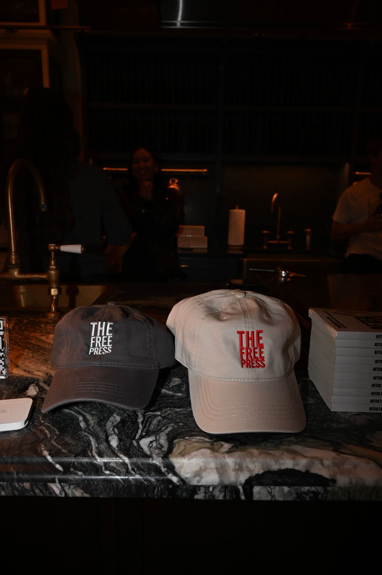 Merchandise on display: The Free Press caps lined up beside stack of books