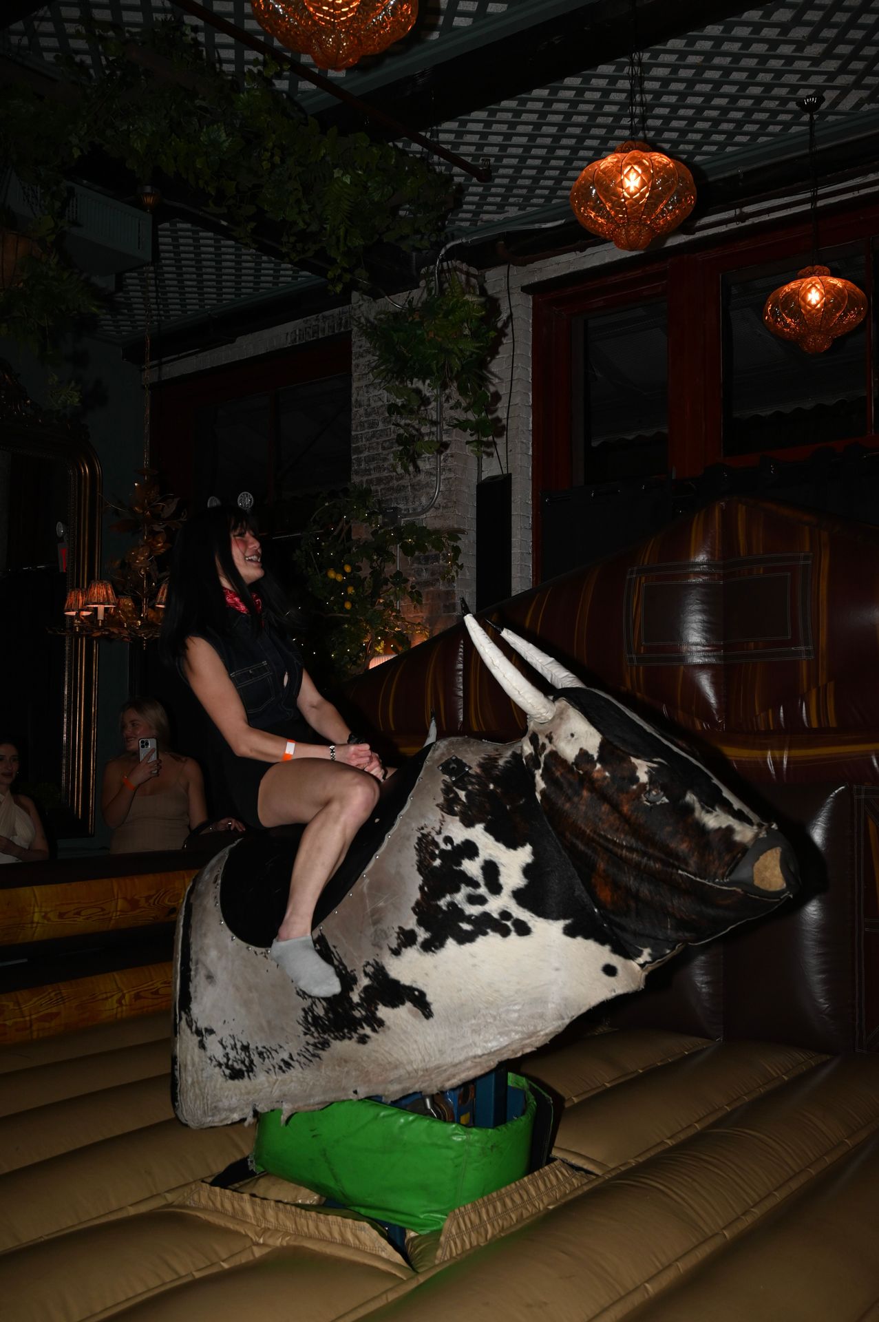 The mechanical bull bucked and twisted as riders clung on, cheered by the crowd