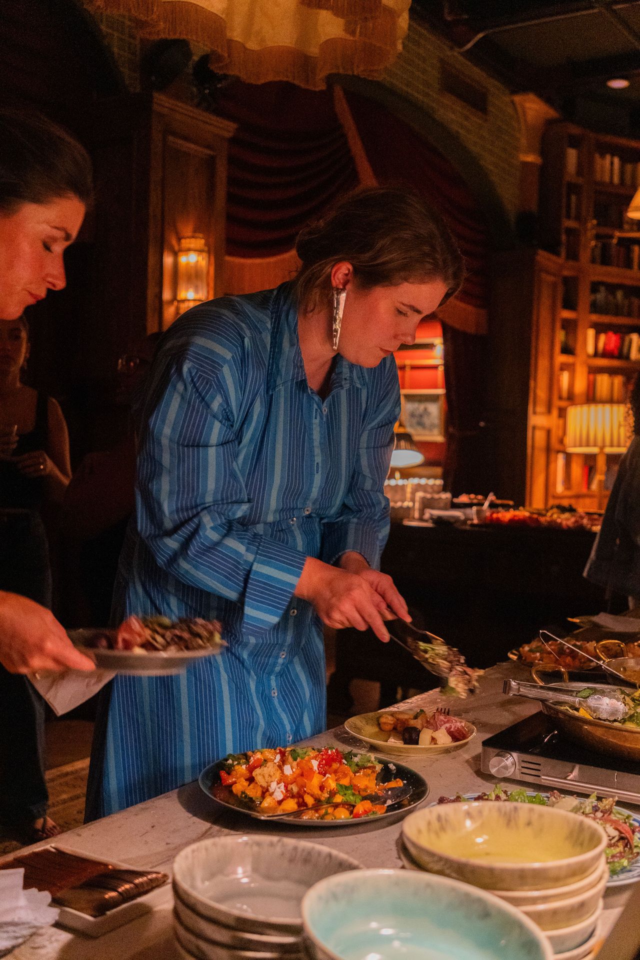 A guest fills their plate with vibrant dishes that celebrated both flavor and seasonality