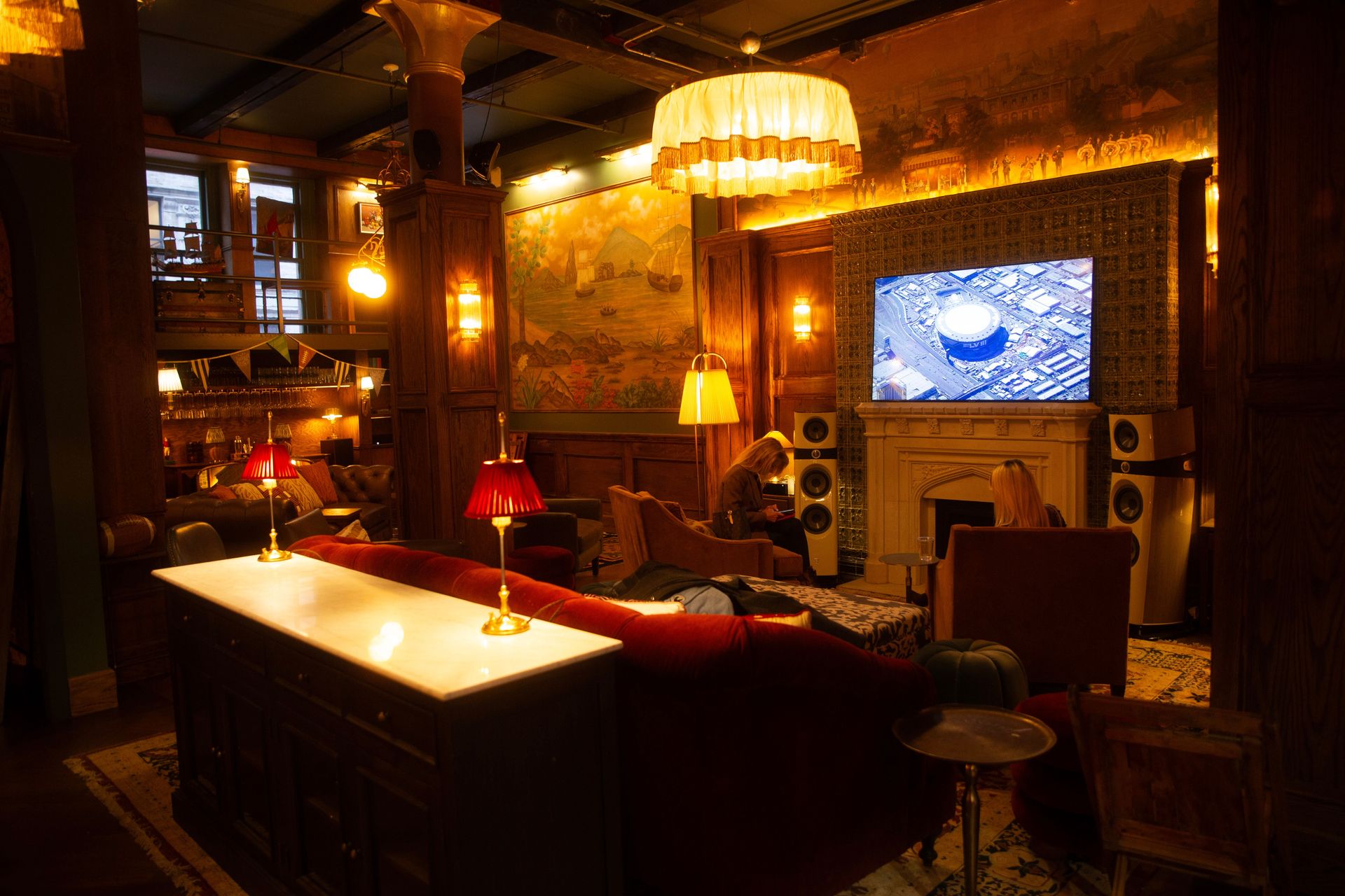 Maxwell’s Grand Room on game day, where the cinematic screen and a golden glow set the stage for an unforgettable viewing experience