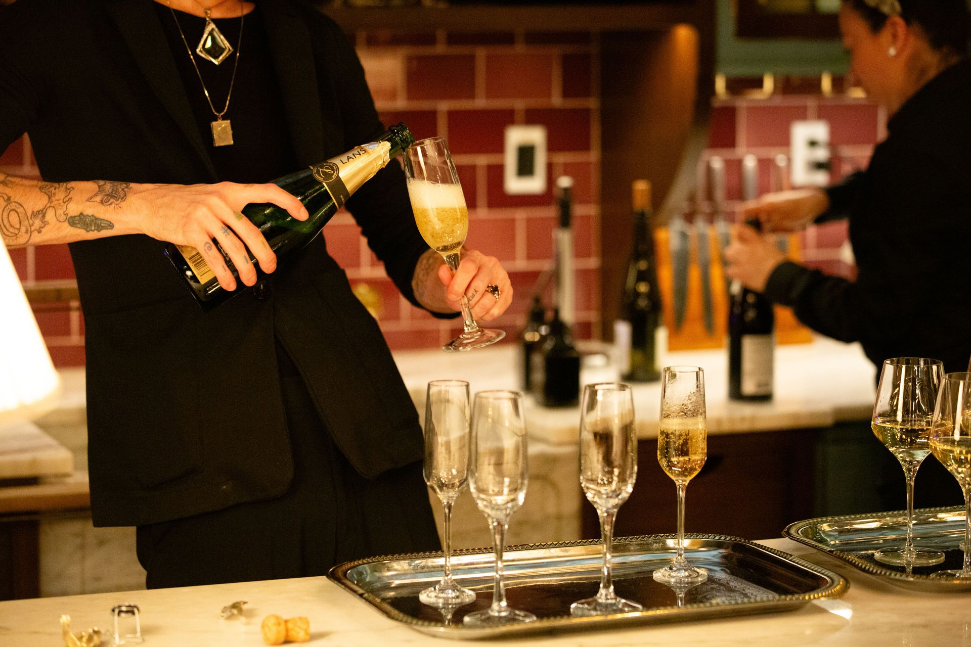 Champagne is poured and served as guests mingle in the Garden Room