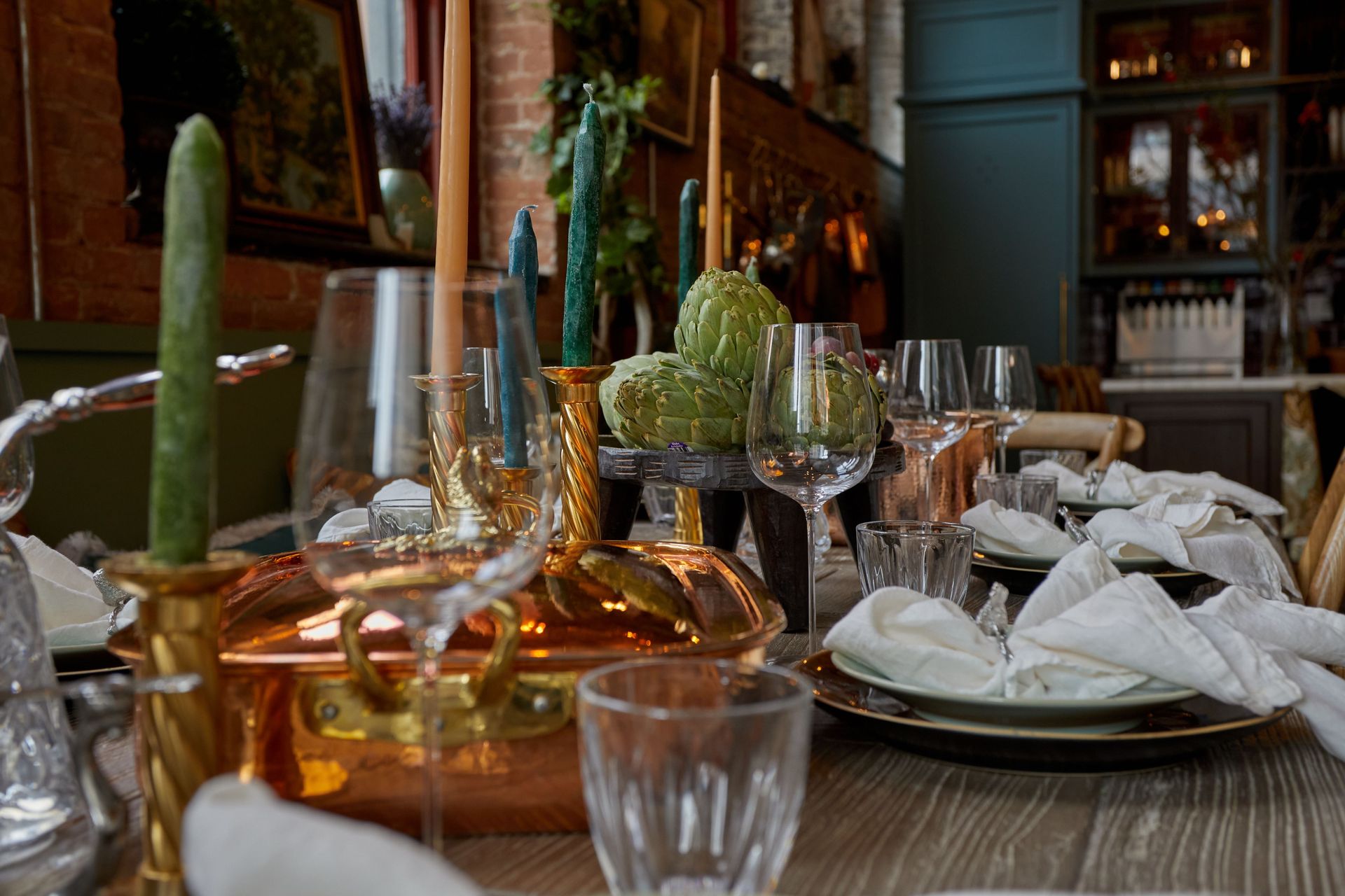 Linen napkins, green candles, glassware, and Ruffoni pieces at Maxwell.
