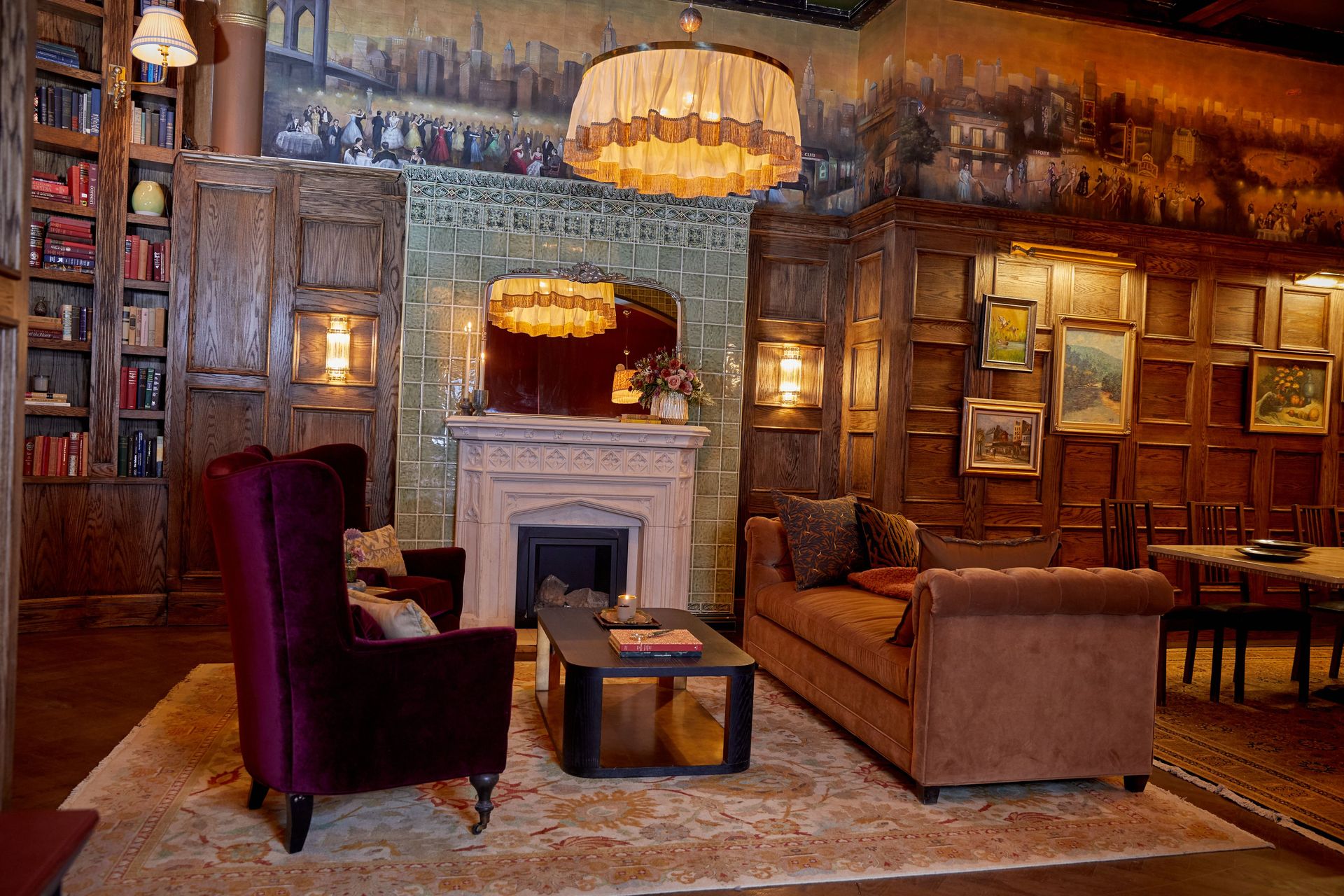 The chandelier ties together seating, artwork, and woodwork, guiding the room from day into night