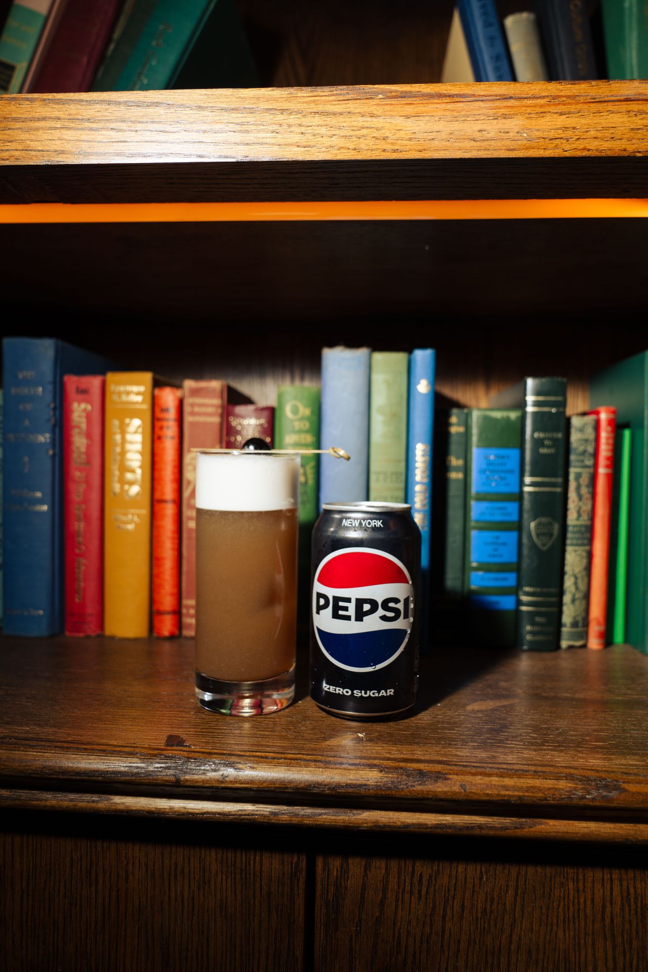 A Pepsi Zero Sugar cocktail, tucked among vintage books
